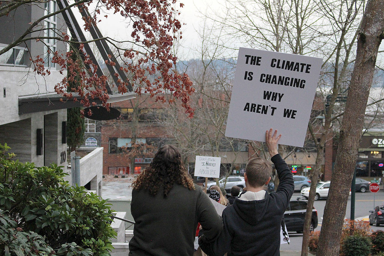 One Kirkland climate change protester holds a sign that reads “The climate is changing. Why aren’t we?” Madison Miller / staff photo