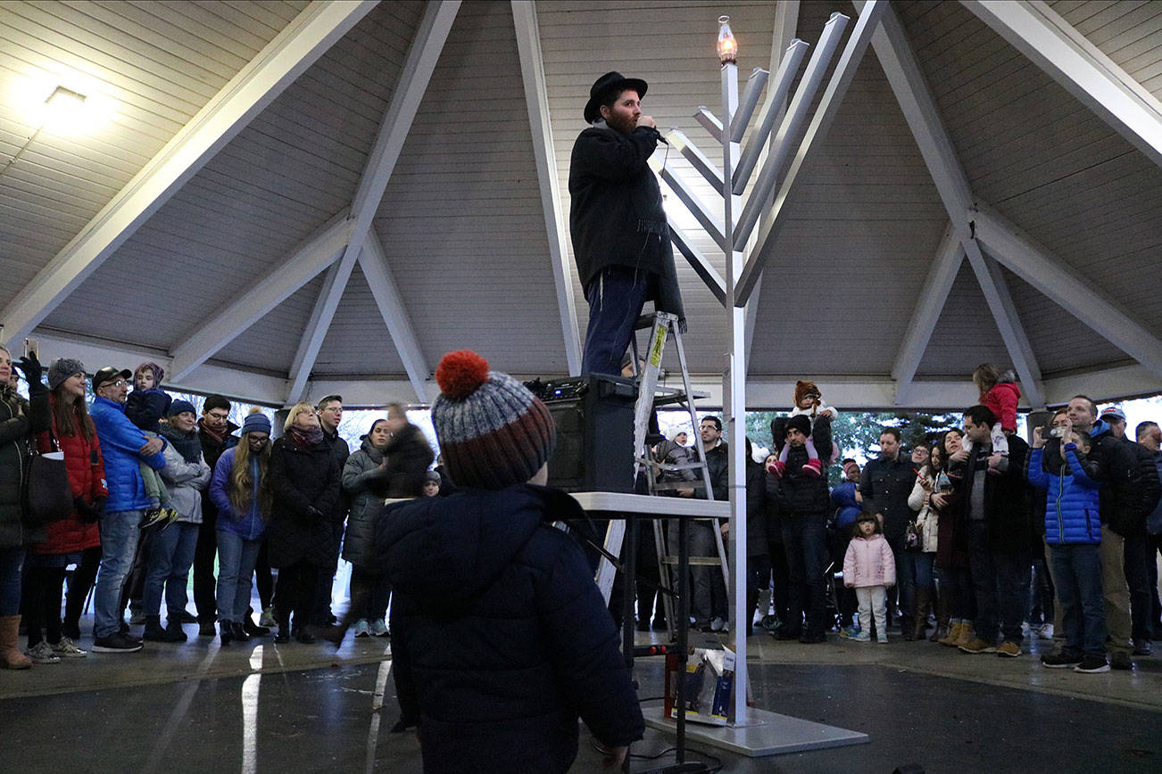 Stephanie Quiroz/staff photo                                 Rabbi Chaim S. Rivkin of Chabad of Kirkland lights the menorah on Dec. 22.