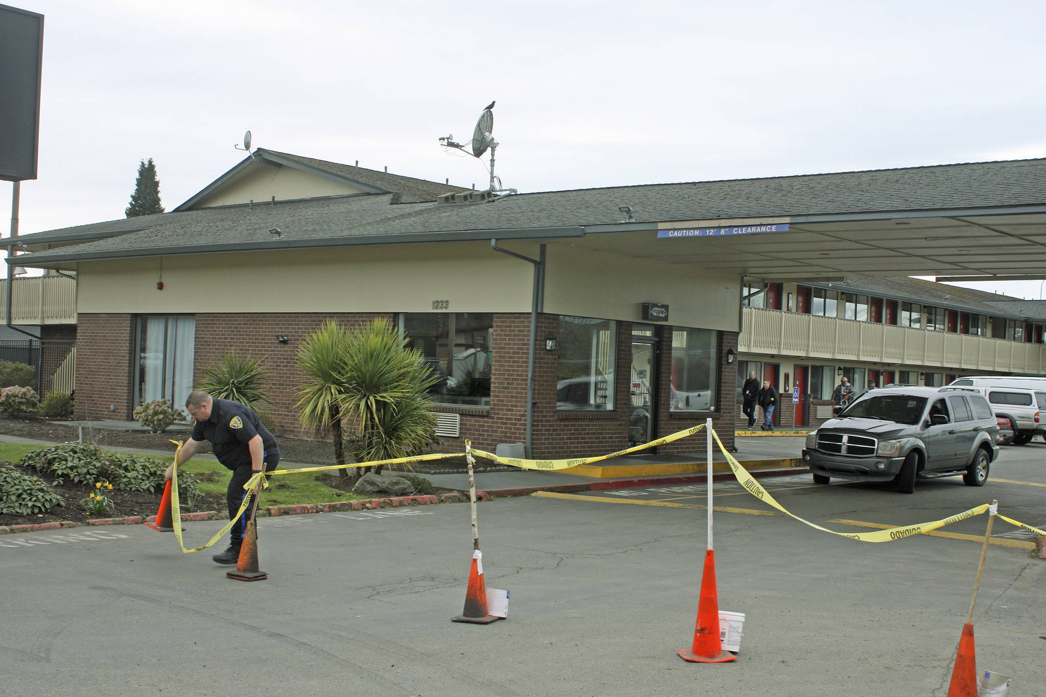 A security guard positions cones as he stands watch in front of the Econo Lodge-turned-coronavirus-quarantine site on Central Avenue North on Tuesday. King County personnel were on site preparing the motel’s transformation into an isolation/quarantine center. MARK KLAAS, Kent Reporter