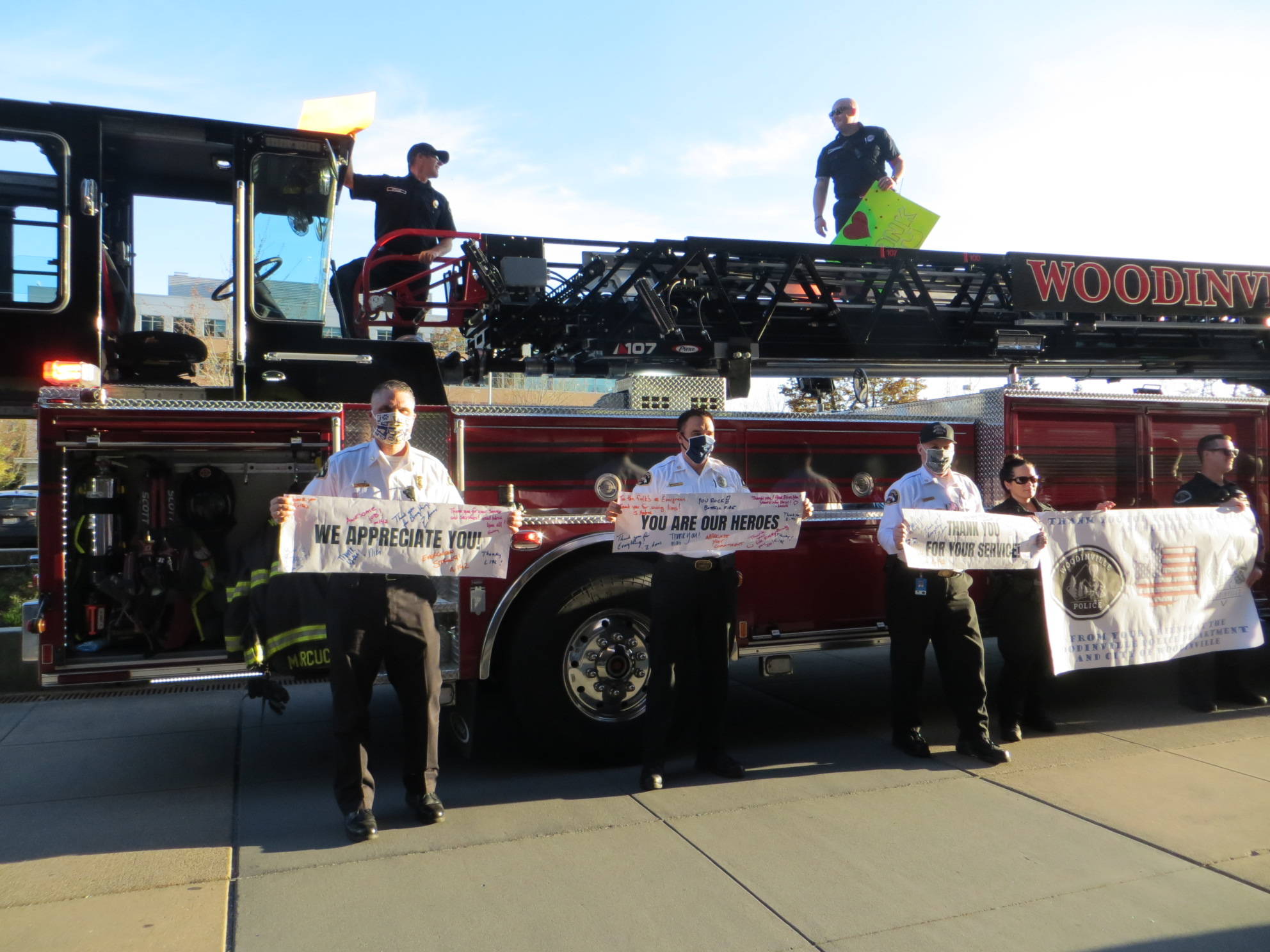 First responders from Woodinville hold up signs thanking the doctors and nurses at EvergreenHealth Medical Center in Kirkland. Samantha Pak/staff photo
