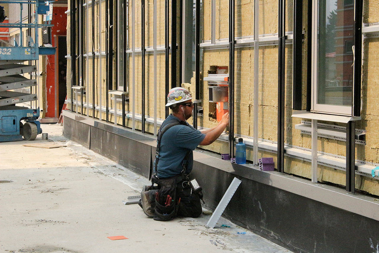 Construction worker installs siding to a building in Snoqualmie. File photo