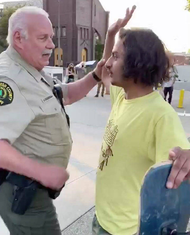 A sheriff’s court marshal arrests a man who dangled a doughnut in front of him. (Screen grab from video courtesy of Bennett Haselton)
