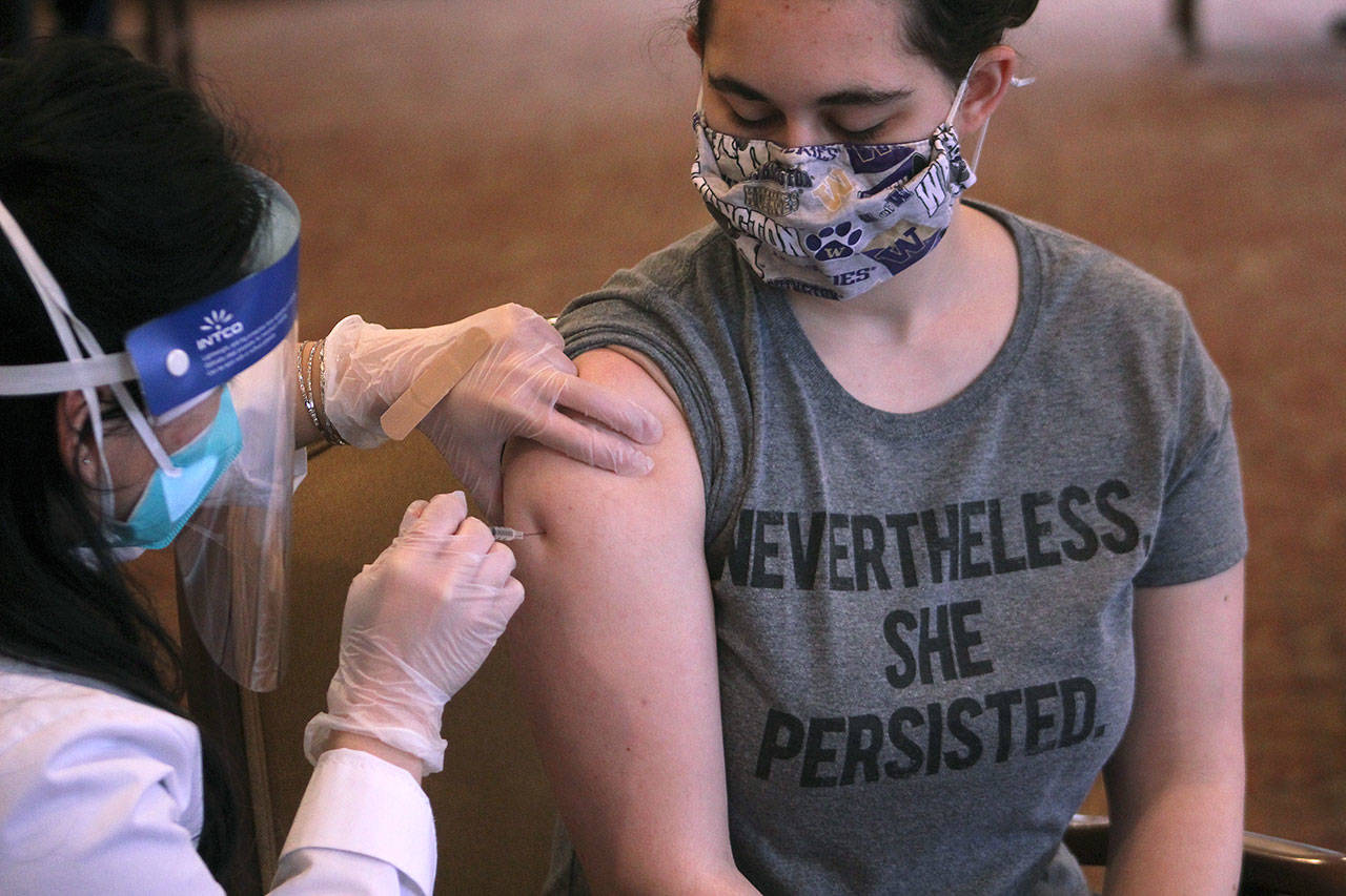 Remi Frederick, a Village Green employee receives her first dose of the Pfizer-BioNTech vaccine on Jan. 26 in Federal Way. Olivia Sullivan/Sound Publishing