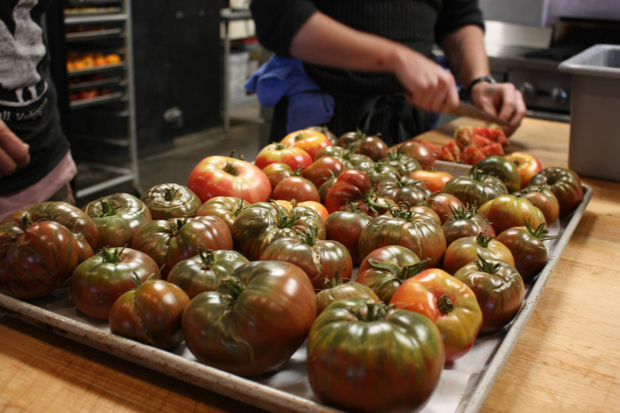 Sarah Cassidy and Chef Kyle Bopes prep heirloom tomatoes from Hearth Farm. Photo by Cameron Sheppard/Sound Publishing