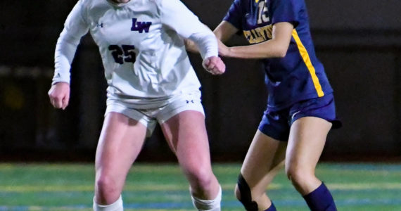 Lake Washington high freshman keeps their eyes on the ball as Bellevue senior Arin Oh (#15) attempts to steal it. Courtesy of Stephanie Ault Justus.