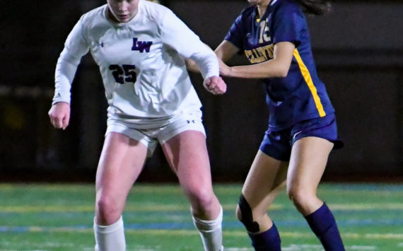 Lake Washington high freshman keeps their eyes on the ball as Bellevue senior Arin Oh (#15) attempts to steal it. Courtesy of Stephanie Ault Justus.