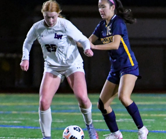 Lake Washington high freshman keeps their eyes on the ball as Bellevue senior Arin Oh (#15) attempts to steal it. Courtesy of Stephanie Ault Justus.