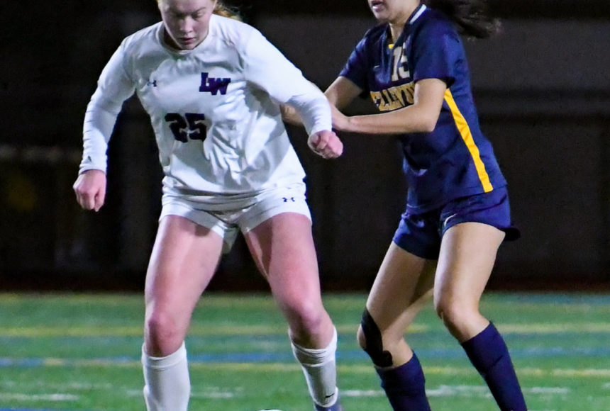<p>Lake Washington high freshman keeps their eyes on the ball as Bellevue senior Arin Oh (#15) attempts to steal it. Courtesy of Stephanie Ault Justus.</p>