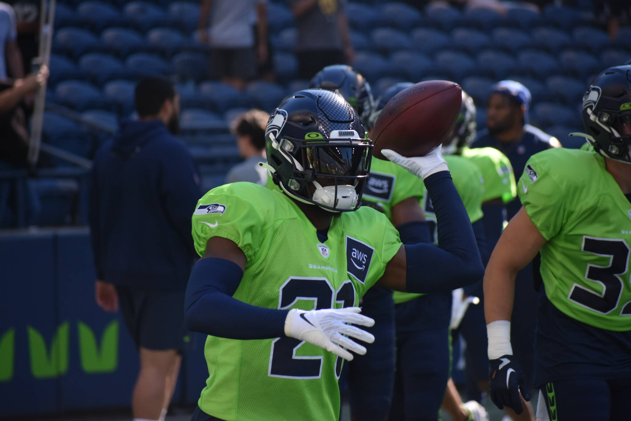 Seahawks first-round pick Devon Witherspoon throws a football to a coach during warm-ups. (Photos by Ben Ray / Sound Publishing)