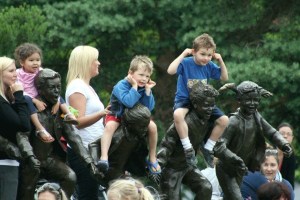 Two boys wiggle their ears and sit on an iconic Kirkland statue during a rendition of Hokey Pokey at Marina Park Tuesday.