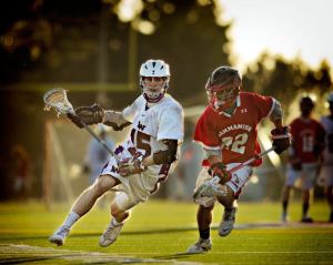 Lake Washington graduate Carson Brown  runs past a Sammamish lacrosse player during a game last year. Starting this upcoming season