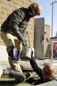 Stellar J workers Jess Hibdon and Oscar Gonzalez clean on March 11 construction-related sediment from a stormwater vault along Park Lane. This was one of the last few tasks workers completed in order to open the street to two-way traffic today.