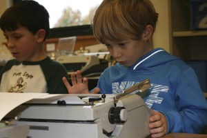 First graders Henry Marks and Ryan Boyd peck away at their typewriters. The students are taught to cross out their mistakes rather than start with a new piece of paper.