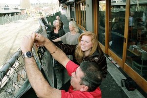 Essentials’ Hailey DeLay helps Mi Mexico’s Jose Angel Villasenor attach a section of the Ben Franklin elementary art project to the Park Lane construction fence while Essentials owner Kara Brodman