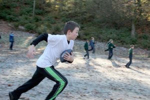 Student Jack Miller runs with the football during recess at Providence Classical Christian School.