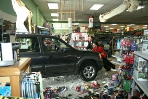 Denny's Pet World employees push an SUV from inside the store late Tuesday afternoon. An elderly woman accidentally drove the vehicle through the storefront and six aisles of merchandise