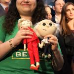 A member of the crowd at the Washington State Democrats election party holds dolls of Hillary Clinton and Bernie Sanders (Allison DeAngelis/staff photo).