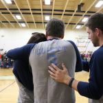Erika Cliett, left, cries into the chest of her father-in-law, Brian Cliett, during a ceremony honoring her late husband, Taylor, at Northest University on Dec. 30. Friends, former teammates and family, including Taylor&rsquo;s brother Jordan Cliett, right, packed the Pavilion and donated thousands of dollars to support Erika and her young daughter, Ellie. JOHN WILLIAM HOWARD/Kirkland Reporter