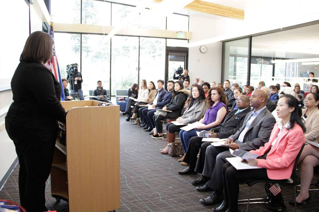 Immigration Services Officer Nicole Al Khafaji speaks to 20 local immigrants before they become U.S. citizens during a naturalization ceremony at the Kingsgate Library. KATHY CUMMINGS / Contributed photo