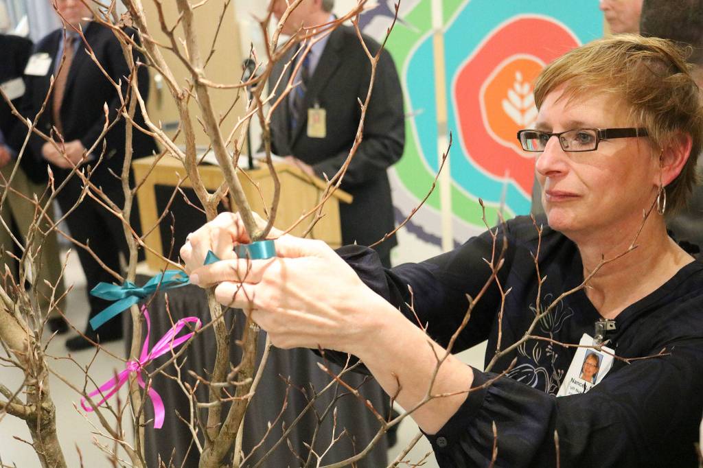 Nancee Hofmeister, Vice President of Nursing and Chief Nursing Officer at EvergreenHealth, ties a ribbon during a dedication ceremony for the hospital&rsquo;s new progressive care unit on Friday, March 3. JOHN WILLIAM HOWARD/Kirkland Reporter