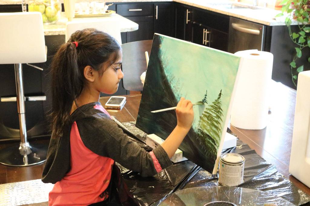 Ira Ganjikunta, 6, works on a painting at her Redmond home. CATHERINE KRUMMEY/Kirkland Reporter