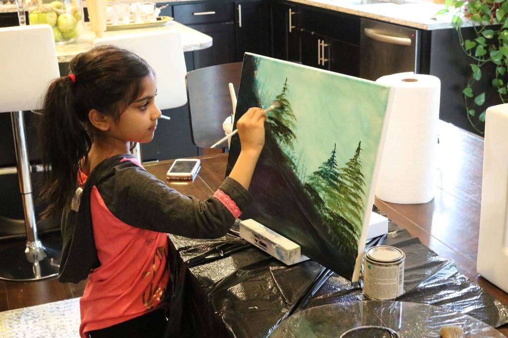 Ira Ganjikunta, 6, works on a painting at her Redmond home. CATHERINE KRUMMEY/Kirkland Reporter