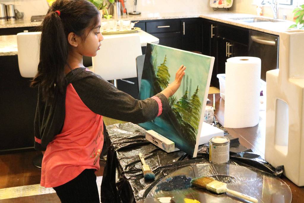 Ira Ganjikunta, 6, works on a painting at her Redmond home. CATHERINE KRUMMEY/Kirkland Reporter