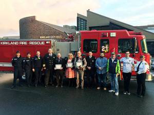 David Chapman, Ronald Davidson and Christina Rancort stand with emergency personnel after being honored by the Kirkland City Council for helping to save a man&rsquo;s life in March. Contributed photo