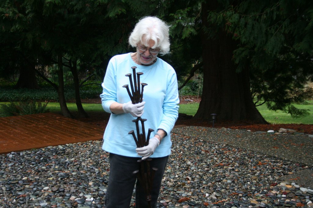 Merrily Dicks holds a sample of &ldquo;The Spikes&rdquo; sculpture that is displayed in her Kirkland backyard. One of her assistants, Yancy McCoy, helped create this piece. The full sculpture has been installed on the Cross Kirkland Corridor. CATHERINE KRUMMEY / Kirkland Reporter