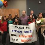 On April 17, Doug Rough (center, in purple shirt) went into cardiac arrest while exercising at the 24 Hour Fitness in Bothell. Steven Charie (to Rough&rsquo;s left, in glasses) performed CPR on Rough and saved his life. They are pictured with members of Rough&rsquo;s family after the City of Kirkland honored Charie. Courtesy of the City of Kirkland