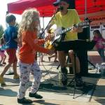 Kids dance alongside a performer at a previous Kirkland Summer Concerts event. Reporter file photo