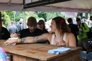 Karen Troy, taproom manager for Black Raven Brewing in Redmond, staffs the kiosk during last weekend&rsquo;s Washington Brewers Festival at Marymoor Park. Aaron Kunkler, Reporter Newspapers
