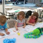 From left to right: Calvin Pohlman, 5, and sisters Emerson, 2, and Payton, 7, color during a community barbecue on National Night Out in Kirkland Tuesday. Megan Campbell/staff photo