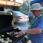 Frank Poulsen, who organized the community barbecue in the 13600 block of 116th Avenue Northeast in Kirkland, grills chicken legs during National Night Out Tuesday. Megan Campbell/staff photo