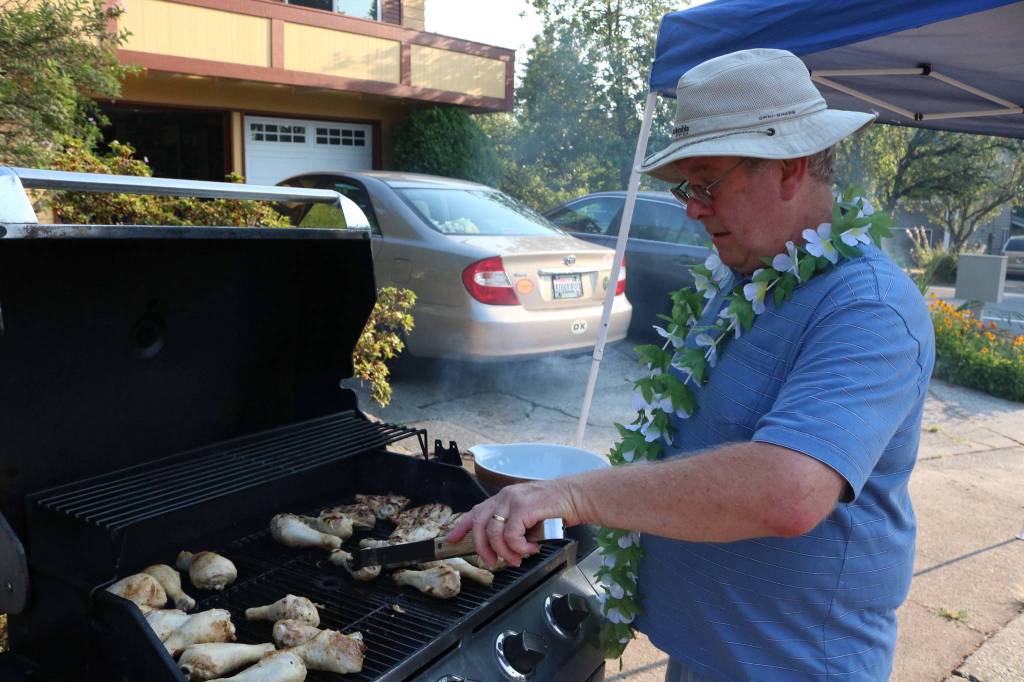 Frank Poulsen, who organized the community barbecue in the 13600 block of 116th Avenue Northeast in Kirkland, grills chicken legs during National Night Out Tuesday. Megan Campbell/staff photo