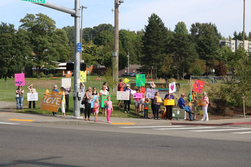 Residents waved and received honks from passing cars as they showed signs of love and peace in downtown Kirkland Monday. Megan Campbell/Kirkland Reporter