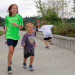 Tegan Estes, 10, and her younger brother Paxton Francois, 3, cross the finish line during the Kirkland Kids Triathlon Saturday. Megan Campbell/Kirkland Reporter