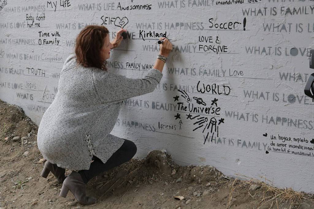 Mayor Amy Walen makes her mark on the newly completed &ldquo;What is…&rdquo; mural located along the Cross Kirkland Corridor underneath Northeast 85th Street during the &ldquo;Crossing Kirkland&rdquo; event Saturday. Megan Campbell/Kirkland Reporter