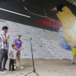 Artist Jake &ldquo;DKoy&rdquo; Wagoner, his son Dylan, 4 1/2, and Mike Lucero speak about the mural during the Crossing Kirkland celebration Saturday. Megan Campbell/Kirkland Reporter