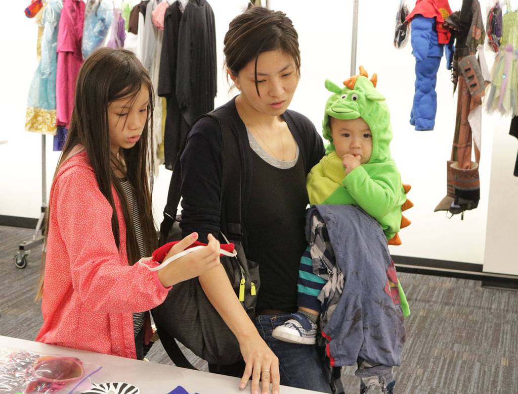 From left to right: Kayla Livingston, 10, her mom, Aiko, and 13-month-old Liam shop around for accessories during the City of Kirkland&rsquo;s Halloween Costume Swap. Megan Campbell/Kirkland Reporter