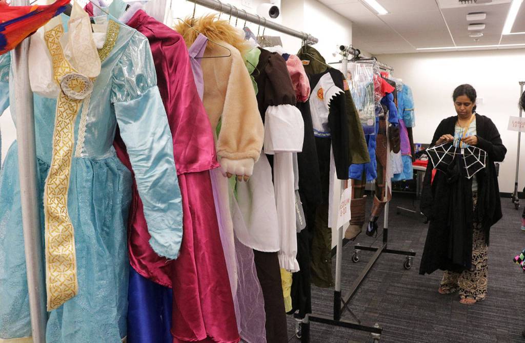 Gauri Pandit examines a witch costume for her 8-year-old daughter during the costume swap Saturday. Megan Campbell/Kirkland Reporter