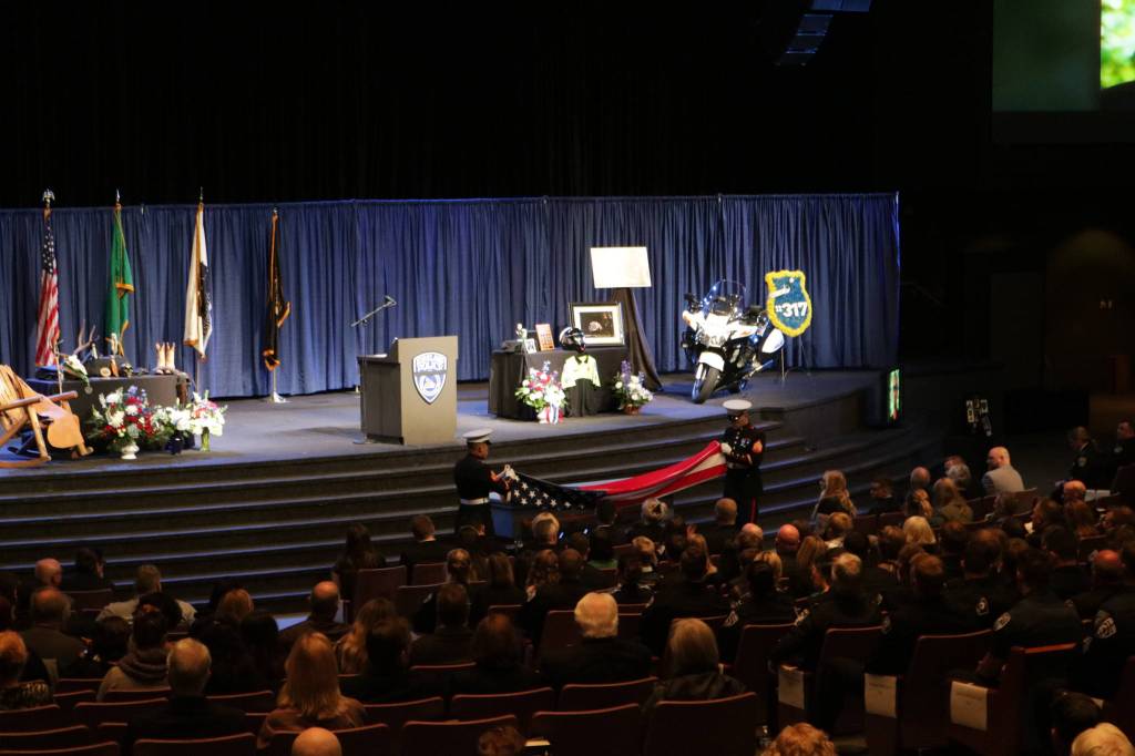 Two U.S. Marines fold an American flag to present to Kirkland police Sgt. Nathan Rich&rsquo;s family. Before joining the department, Rich served in the U.S. Marine Corps. Samantha Pak, Kirkland Reporter