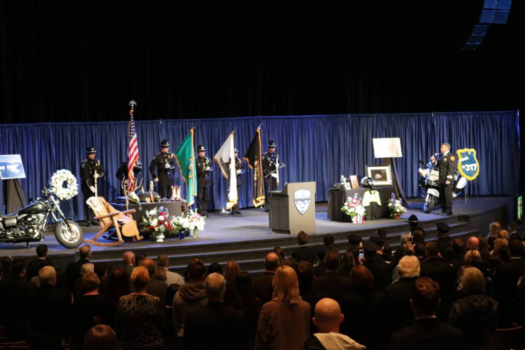 The color guard and the audience stands at attention for the national anthem, performed by Capt. Keith Sessions of South Snohomish County Fire and Rescue RFA, at Sgt. Nathan Rich&rsquo;s memorial service. Samantha Pak, Kirkland Reporter