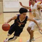 Juanita Rebels guard Darius Johnson, left, tries to maneuver around Bellevue senior Spencer Birkeland in the KingCo 3A title game on Feb. 7 at Newport High School in Factoria. Courtesy of Don Borin, Stop Action Photography