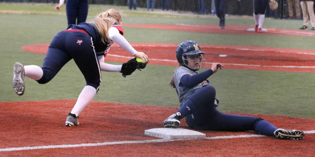 Juanitas Abbie Reynolds balances herself after tagging out a West Seattle runner at third. Andy Nystrom / staff photo