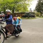 Michelle Plesko rides her motor-assisted cargo bicycle home on South Rose Hills Northeast 75th Street from her 3-year-old twins swim practice in the Highlands. Plesko, the executive director of Kirkland Greenways, said her bike-commuting began in 2012 with drop-offs and pick-ups at her childrens school. I think its easier than driving, she said. I drive two to three days a week. And those are so stressful. I have to worry about traffic and parking.                                Boaz Hall, 7, sells Kirkland Assistant City Manager Jim Lopez fresh squeezed lemonade and peanut butter cookies April 24 on 128th Avenue Northeast, just north of Mark Twain Elementary School. Lopez and Kirkland Public Works Director Kathy Brown toured the Northeast 75th Street and 128th Avenue Northeast greenways on April 24 with members of the Neighborhood Greenways project team. The City of Kirkland is planning to begin construction on the Northeast 75th Street Greenway this summer and to begin construction on the 128th Avenue Northeast Greenway next summer.