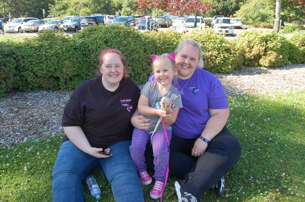 Loving Pets & Paws owner Brea Post (right) smiles with Ruby the bearded dragon, lead pet sitter Lauren Holmes and her daughter and pet sitter in training Julia Post at Kirklands Pet-a-Palooza. Katie Metzger/staff photo