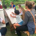 Families learn to draw at Summerfest, Kirklands annual music and arts festival. Katie Metzger/staff photo