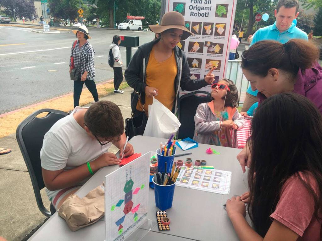 Kids and families make origami robots at the KirklandReads booth at Summerfest. Katie Metzger/staff photo