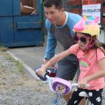 A young girl gets a boost while riding her bike along the Cross Kirkland Corridor. Katie Metzger/staff photo